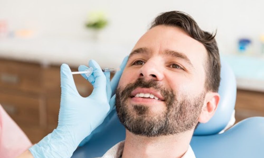 Closeup of mid adult man smiling while undergoing anti-aging treatment